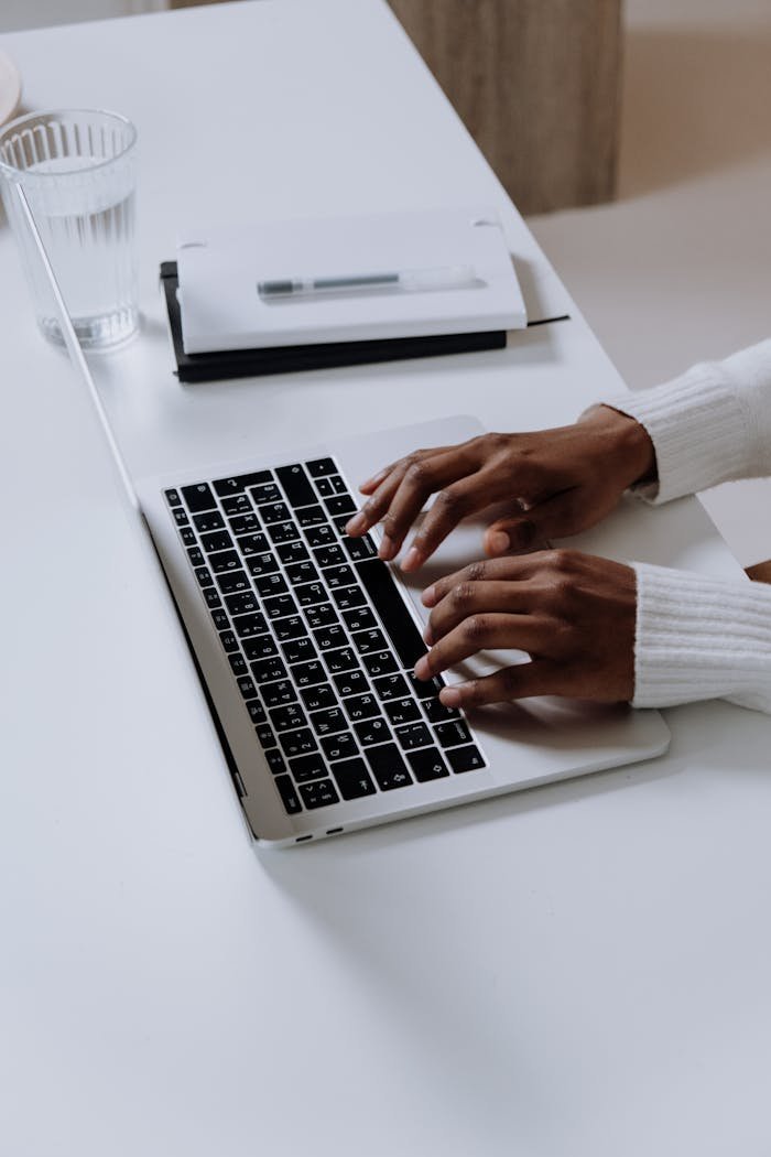 Person Using Macbook Pro on White Table